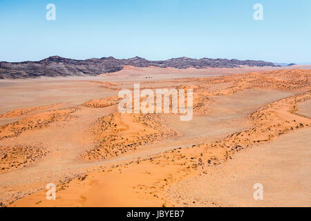 Typische trostlos, öde, trockenen bergigen Gelände der Namib-Wüste mit ockerfarbenen Dünen auf der Skeleton Coast, Namibia, Südwest-Afrika Stockfoto