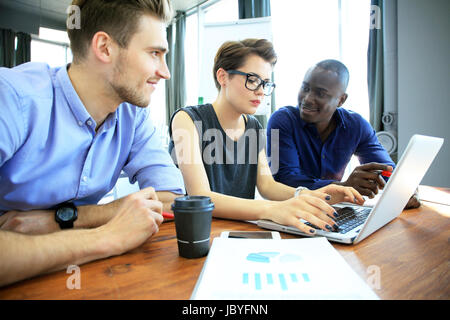 Teamwork, Brainstorming-Konzept. Junge kreative Manager-Team arbeitet mit neuen Startprojekt in modernen Büro. Moderne Notebooks auf Holztisch. Drittwirkung film Stockfoto