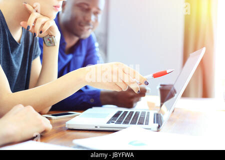 Teamwork, Brainstorming-Konzept. Junge kreative Manager-Team arbeitet mit neuen Startprojekt in modernen Büro. Moderne Notebooks auf Holztisch. Drittwirkung film Stockfoto