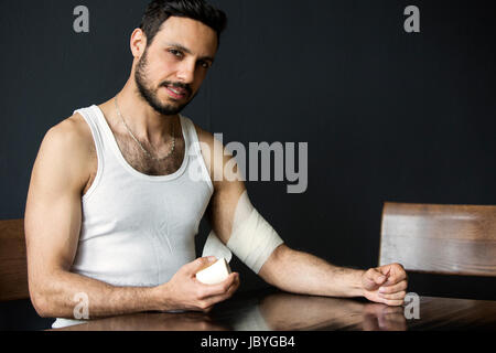 Porträt von gut aussehender Mann, Verband in seinen arm Stockfoto