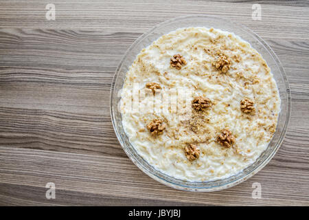 Gullac, türkische traditionelle Milch Dessert mit Walnuss auf hölzernen Hintergrund Stockfoto