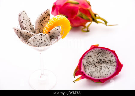 Weißes Fruchtfleisch der halben Pitaya in Keile geschnitten und in ein Glas präsentiert. Die dekorative Mandarine Scheibe ist auch der Pitaya Geschmack ergänzen. Stockfoto