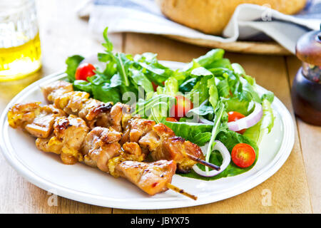 Gegrillter Hühnerspieß mit Rucola-Salat mit Brot Stockfoto