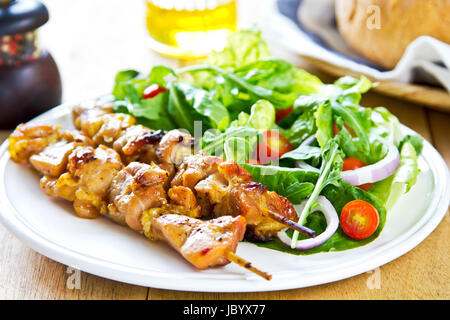 Gegrillter Hühnerspieß mit Rucola-Salat mit Brot Stockfoto