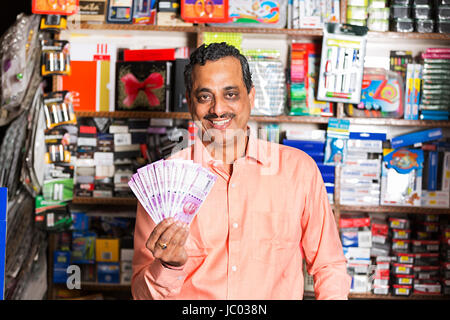 1 Indischer Ladenbesitzer Mann mit Geld Rupien in stationären Shop Stockfoto