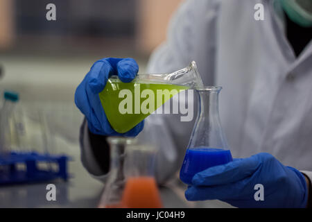 Forscher oder Wissenschaftler oder Doktoranden mischen Grün und Blau chemische Verbindungen, die in der Biotechnologie Labor Stockfoto