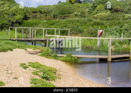 Der entfernte hölzerne Fussgängerbrücke auf dem Solent Weg, Southampton Water Ende der Haken Lane Reitweg in der Nähe von Titchfield häufig in Hampshire Stockfoto