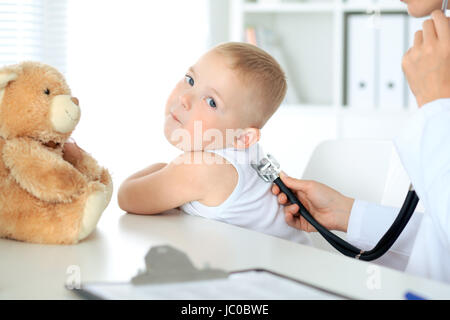 Glücklicher kleine junge Spaß beim ist von Arzt mit Stethoskop untersuchen wird. Gesundheitswesen, Versicherungen und Hilfe-Konzept Stockfoto