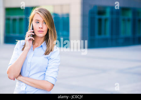 Erfolgreiche Unternehmerin oder Unternehmer sprechen über Handy beim gehen im Freien. City-Business-Frau arbeiten. Stockfoto