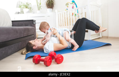 Porträt der glückliche Mutter zu Hause Sport und Spaß mit ihrem Babyjungen Stockfoto