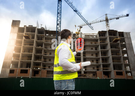 Rückansicht-Schuss von Bauingenieur posiert auf der Baustelle in hellen sonnigen Himmel Stockfoto