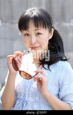 Porträt von Hand junge Japanerin, die braune Sonnenbrille Stockfoto