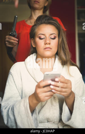 Getönten Portrait schöne Braut zu Hochzeit und mit Handy Vorbereitung Stockfoto