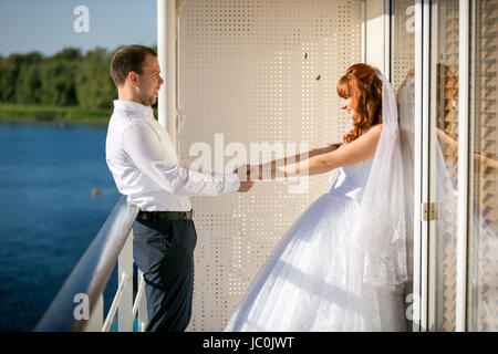 Frisch verheiratetes Paar Hand in Hand auf Deck des Kreuzfahrtschiffes Stockfoto