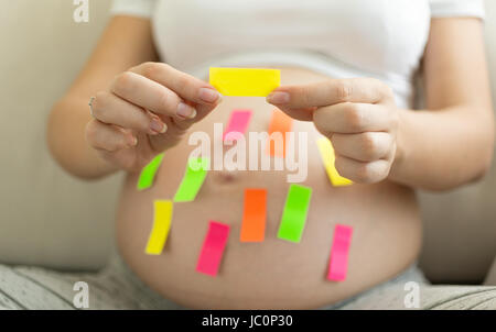 Junge schwangere Frau mit bunten Memo-Sticker Stockfoto