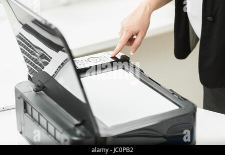 Nahaufnahme Foto der Geschäftsfrau Pressen Drehknopf am Kopiergerät im Büro Stockfoto