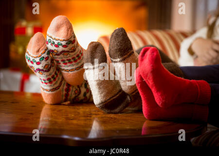 Nahaufnahme Foto der Familie Füße in Wolle Socken am Kamin Stockfoto