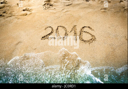 Closeup Aufnahme von 2016 Ziffern geschrieben am nassen Sand am Meeresstrand Stockfoto