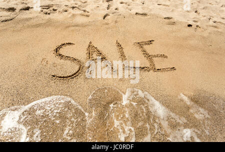 Konzeptionelle Schuss von Verkauf geschrieben am Sandstrand Stockfoto