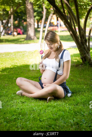 Konzeptionelle Foto schwangere Frau Lutscher für ungeborene Kind geben Stockfoto