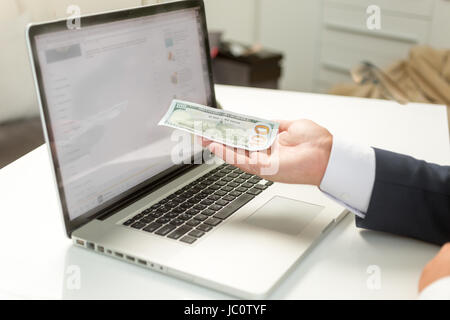 Nahaufnahme Foto des Kaufmanns Banknote auf Seite halten und geben es an computer Stockfoto