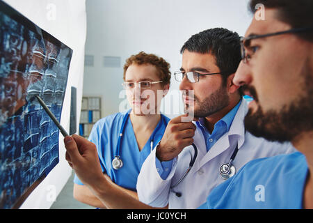 Junge männliche Ärzte Röntgen aufmerksam zu betrachten und zu diskutieren Stockfoto