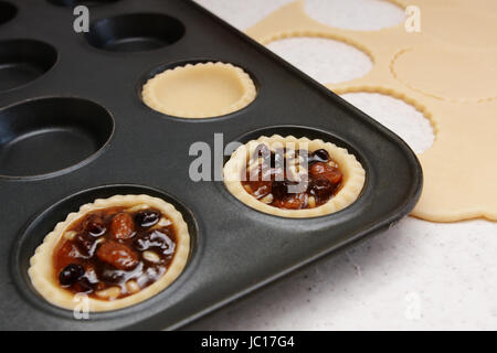 Herstellung Mince Pies - Gebäck-Fällen mit traditionellen Hackfleisch gefüllt Stockfoto