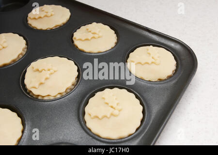 Mince Pies Konserve Brötchen bereit für den Ofen mit Gebäck Holly Blatt Dekoration Stockfoto