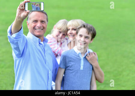 Vater nimmt ein Familienfoto im Freien. Stockfoto