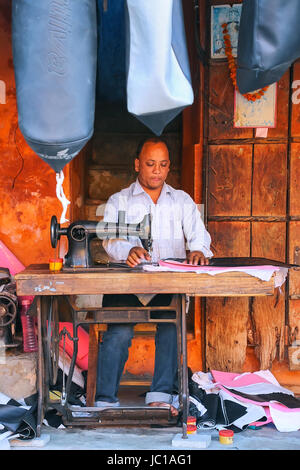 Lokaler Mann machen Motorrad Sitz deckt Johari Bazaar Street in Jaipur, Rajasthan, Indien. Jaipur ist die Hauptstadt und größte Stadt von Rajasthan. Stockfoto