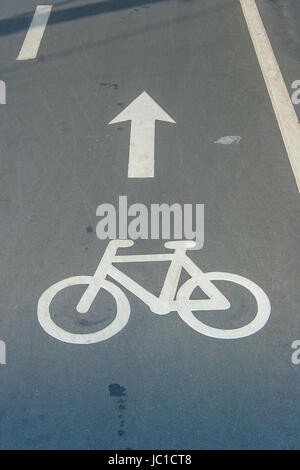 Bike-Lane-Zeichen und Richtung auf Asphaltstraße Stockfoto