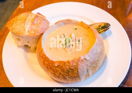 Nahaufnahme von einem Sauerteig Clam Chowder Gourmet-Teller. Eine cremige Suppe aus Muscheln und Gemüse im Brotlaib serviert durch das Entfernen der Spitze, eine leckere Mahlzeit in der fishermans Wharf in San Francisco. Stockfoto