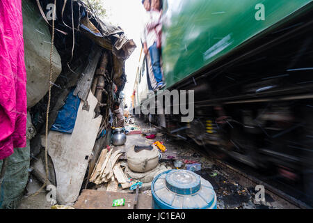 Die Wohnungen und Hütten in China Bazar Slumgebiet befinden sich direkt neben den Gleisen, ein Zug, der durch Stockfoto