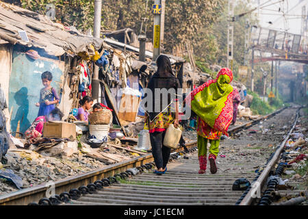 Die Wohnungen und Hütten in China bazar Slumgebiet befinden sich direkt neben den Gleisen, die Leute sind zu Fuß auf den Spuren Stockfoto