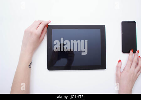 weiße Tablette mit einem leeren Bildschirm in den Händen auf weißem Hintergrund Stockfoto