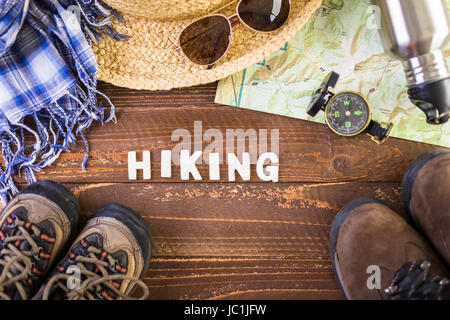 Wanderschuhe mit Topo Karte und Kompass auf Holz Hintergrund. Stockfoto