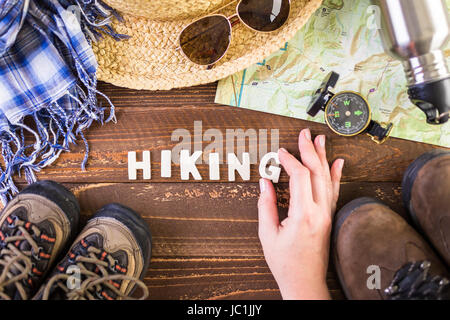 Wanderschuhe mit Topo Karte und Kompass auf Holz Hintergrund. Stockfoto