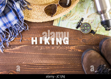 Wanderschuhe mit Topo Karte und Kompass auf Holz Hintergrund. Stockfoto