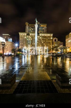 Eine Nacht-Blick auf den Union Square in der Innenstadt von San Francisco, California, Vereinigte Staaten von Amerika. Ein Wahrzeichen der Gegend mit einer Spalte mit einer Statue des Sieges hält einen Dreizack im Herzen des Stadtzentrums an der Spitze. Stockfoto