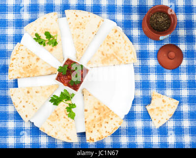 Tortillas mit Basilikum auf Teller und blaue Serviette geschnitten Stockfoto