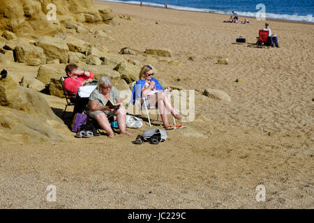 West Bay, Dorset, UK. 13. Juni 2017. Strandurlauber genießen die Sonne am Abend nach einem herrlich sonnigen Tag in West Bay an der Küste von Dorset Credit: Tom Corban/Alamy Live News Stockfoto