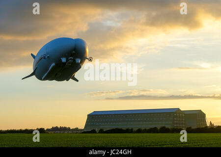 Cardington, Bedfordshire, Großbritannien. 13. Juni 2017. Die Hybride Luft fahrzeuge Airlander 10 Weiterhin ist es Flight Test Programm 2017. In Ruhe trocknen Wetter mit Sonnenschein und kleine Wolke in Cardington Flugplatz es große Kreise der lokalen Landschaft mit drei Touch und übergibt sie an der Mooring, bevor schließlich die Landung als die Sonne unterging. Steilen Aufstieg mit dem riesigen luftschiff Hangars im Hintergrund. Photo Credit: Mick Flynn/Alamy leben Nachrichten Stockfoto