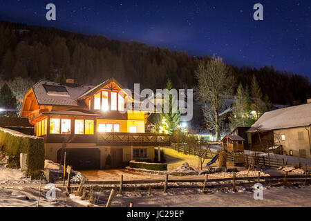 Schönes Holzchalet auf österreichischen Hochalpen in der sternenklaren Nacht Stockfoto