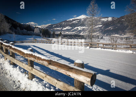 Schöne Aussicht auf Bergstrasse unter dem Schnee in den österreichischen Alpen am sonnigen Tag Stockfoto