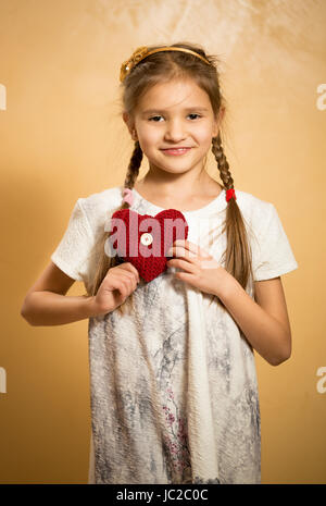 Porträt der niedliche kleine Mädchen halten dekorative rote Herzen Stockfoto