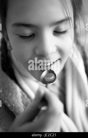 Schwarz / weiß Foto von kleinen Mädchen, die Einnahme von Medikamenten auf Löffel Stockfoto