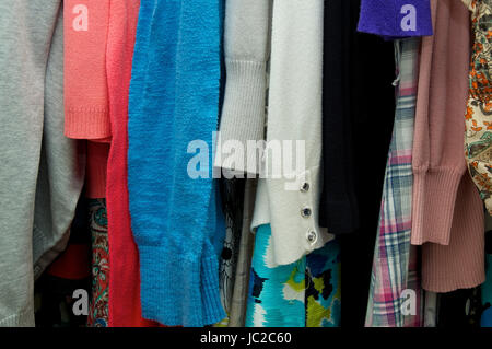 Nahaufnahme eines Weibes Kleidung hängen im Schrank, mit verschiedenen Materialien und Farben Stockfoto