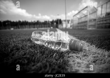 Schwarz / weiß Aufnahme der Flasche Wasser am Fußballplatz liegen Stockfoto