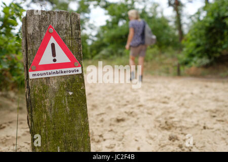 Warnschild im Wald für Wanderer, überqueren eine Mountainbike-Strecke Stockfoto