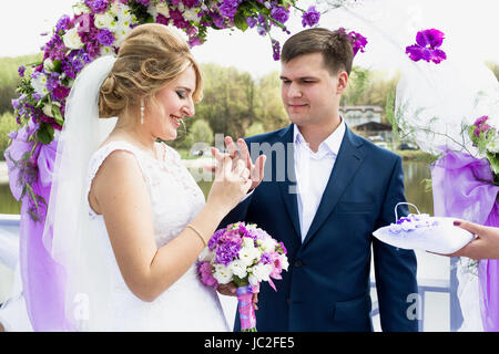 Porträt der glückliche Braut Bräutigam Hand bei Trauung goldene Ring aufsetzen Stockfoto